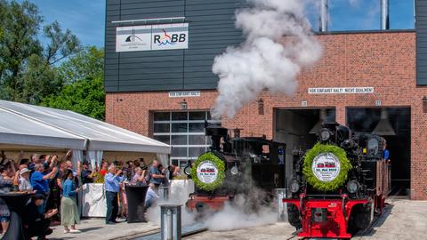 Der Moment der Eröffnung der neuen Werkstatt der RüBB und der Erlebniswelt im Bahnhof Putbus am 24. Mai 2024 mit den geladenen Gästen sowie den Loks I K Nr. 54 und 99 4652.
