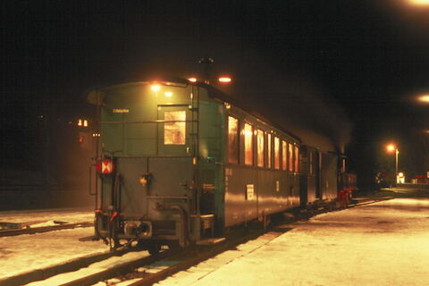 Der fetzte Zug des Jahres 2003 bestand bei der Preßnitztalbahn in der Silvesternacht nur aus der IV K 99 590 und zwei Reisezugwagen dem neu aufgebauten Packwagen 974-331 und dem Buffetwagen 970-458, hier im Bahnhof Schmalzgrube.